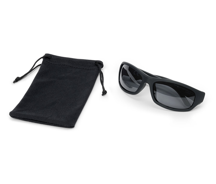 Des lunettes de soleil noires sont posées à côté d'un sac noir avec cordon de serrage.