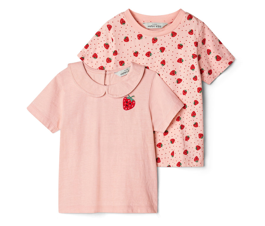 Deux t-shirts pour enfant. Un t-shirt rose clair avec un col Claudine et une broderie fraise souriante est posé devant un t-shirt rose foncé à motif fraises et pois.