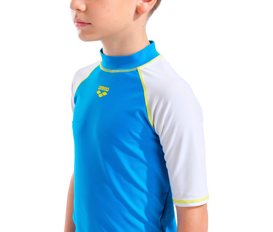 Gros plan sur un enfant portant un maillot de bain Arena bleu et blanc.