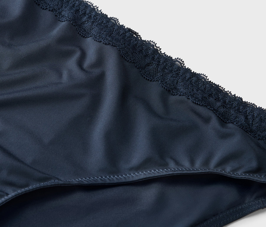 Gros plan sur une culotte marine pour femme avec des finitions en dentelle.