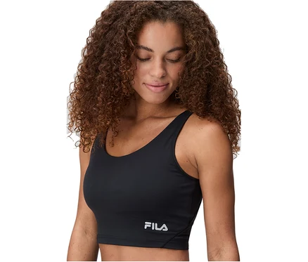 Femme aux cheveux bruns bouclés portant une brassière de sport noire FILA, regardant vers le bas.