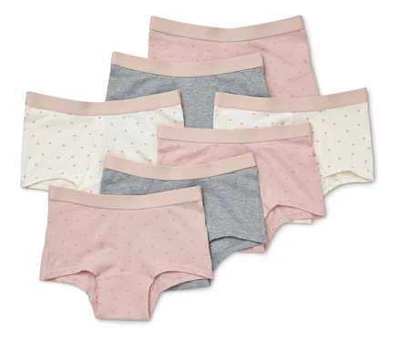 Sept culottes courtes pour femmes de couleur rose, grise et blanche avec de délicats motifs à pois, disposées les unes sur les autres.