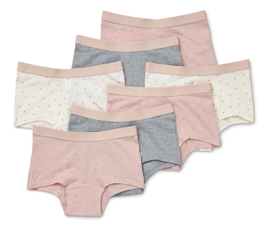 Sept culottes courtes pour femmes de couleur rose, grise et blanche avec de délicats motifs à pois, disposées les unes sur les autres.