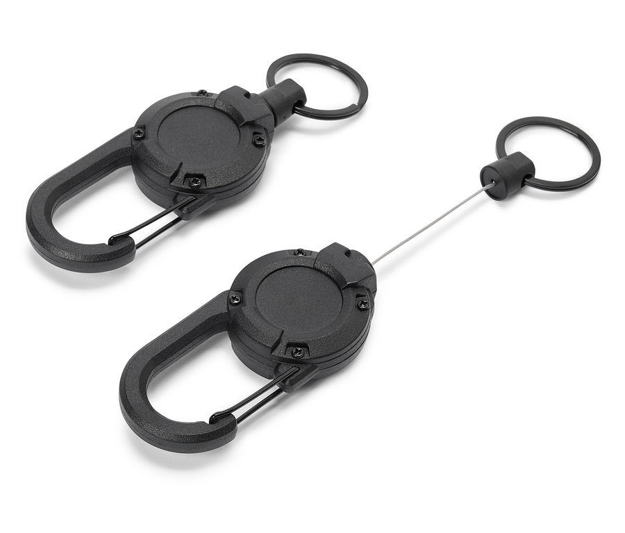 Deux porte-clés rétractables noirs avec mousquetons reposent sur un fond blanc.