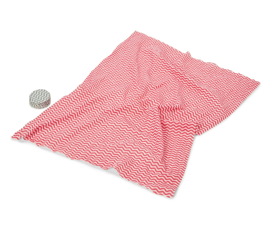 Un tissu rouge et blanc ondulé est posé sur un fond blanc, à côté d'un rouleau avec un motif similaire.