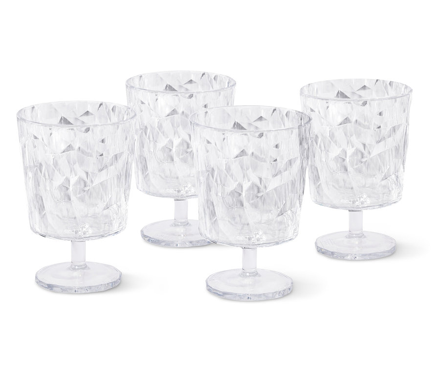 Quatre verres à vin vides et transparents avec un motif à facettes se tiennent sur un fond blanc.