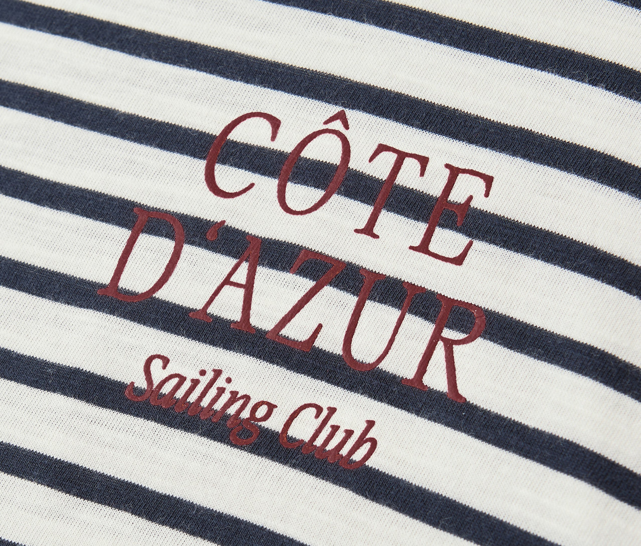 Gros plan sur le t-shirt Street One bleu marine et blanc avec l'inscription rouge « Côte D'Azur Sailing Club ».