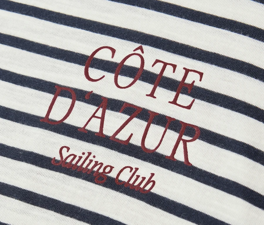 Gros plan sur le t-shirt Street One bleu marine et blanc avec l'inscription rouge « Côte D'Azur Sailing Club ».