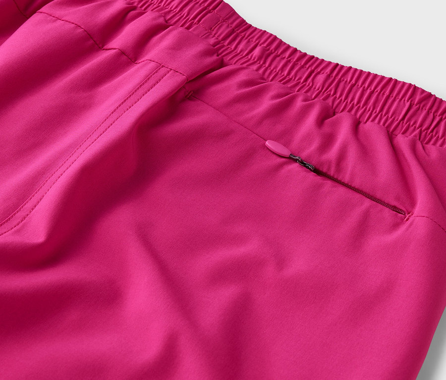 Gros plan d'un pantalon rose avec une taille élastique et une poche zippée.