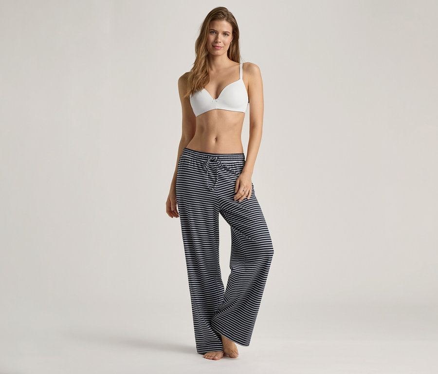 Femme portant un soutien-gorge à coques souples blanc et un pantalon rayé bleu et blanc.