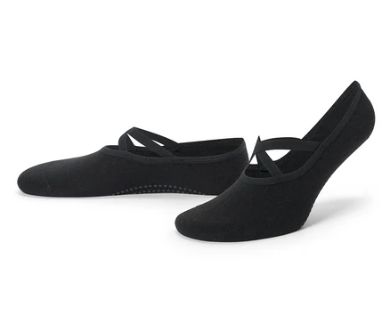 Une paire de chaussons de yoga noirs avec des sangles croisées et des picots antidérapants.