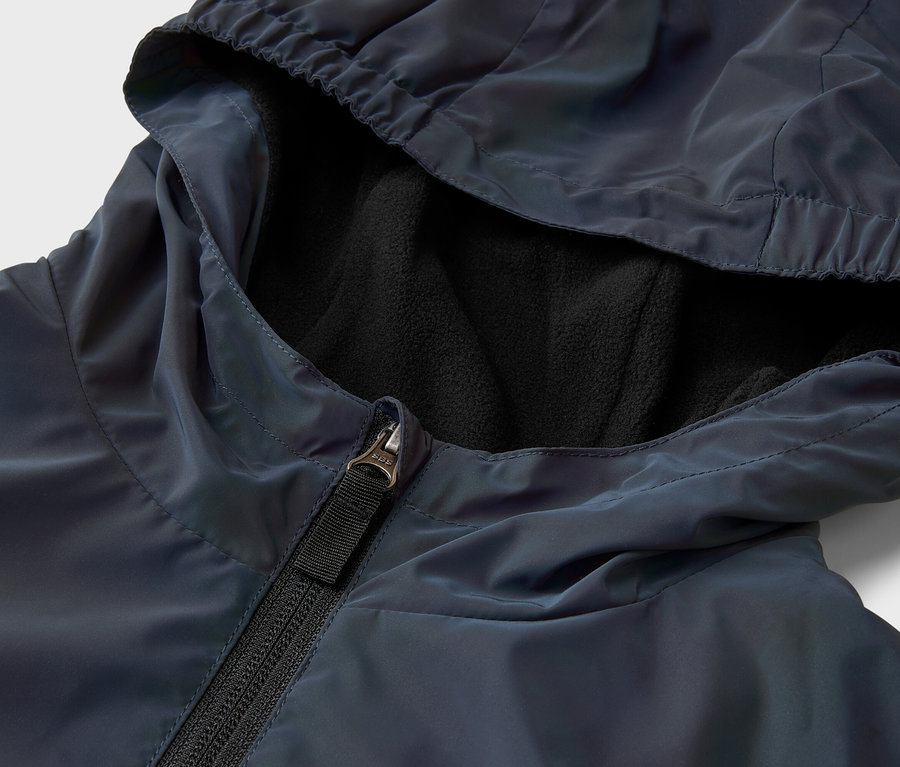 Gros plan d'une veste bleu marine ouverte avec capuche et doublure polaire noire.