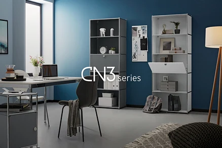 Mobilier de bureau avec des étagères, un bureau, une chaise et une lampe devant un mur bleu.