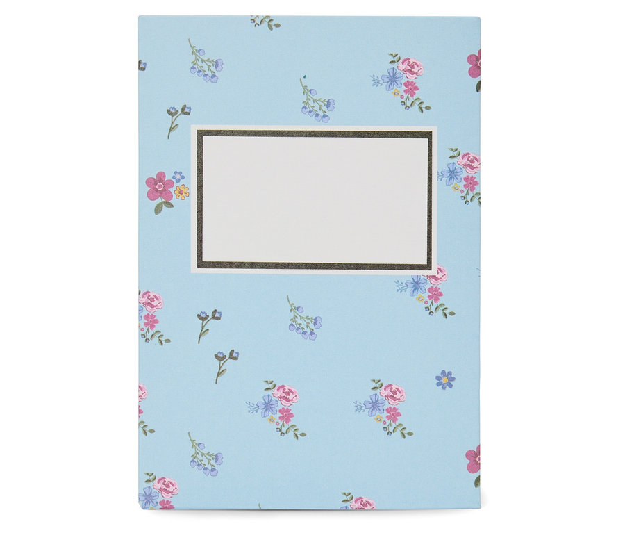 Carnet avec motif floral bleu et étiquette blanche au centre.