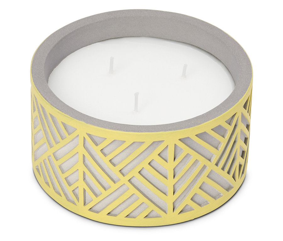 Une grande bougie à trois mèches dans un récipient jaune avec un motif géométrique et un bord gris.