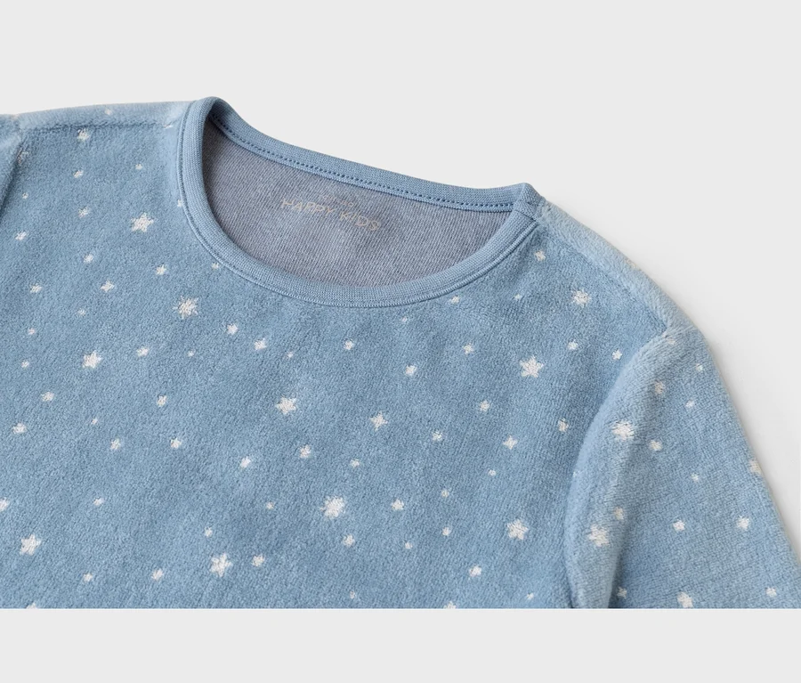 Gros plan d'un haut doux bleu clair à col rond, orné d'étoiles blanches de différentes tailles. Le texte « HAPPY KIDS » est subtilement visible à l'intérieur du col.