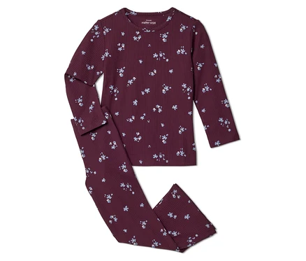 Un pyjama enfant côtelé bordeaux avec un motif floral bleu et blanc, composé d'un haut à manches longues et d'un pantalon long assorti.