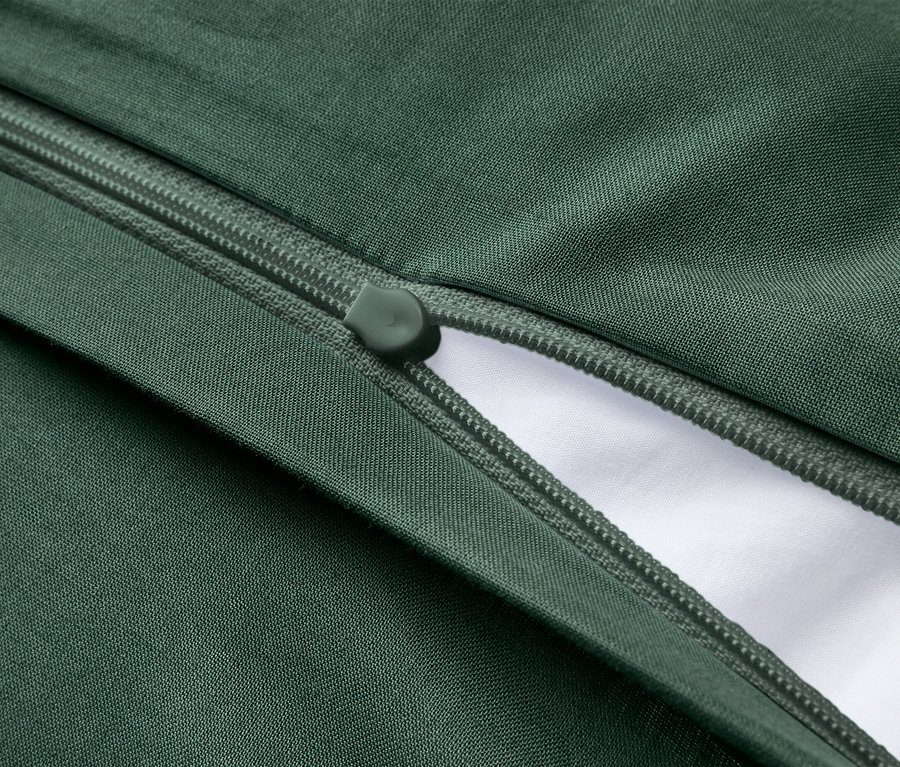 Tissu vert foncé avec une fermeture éclair vert foncé partiellement ouverte, révélant du tissu blanc en dessous.