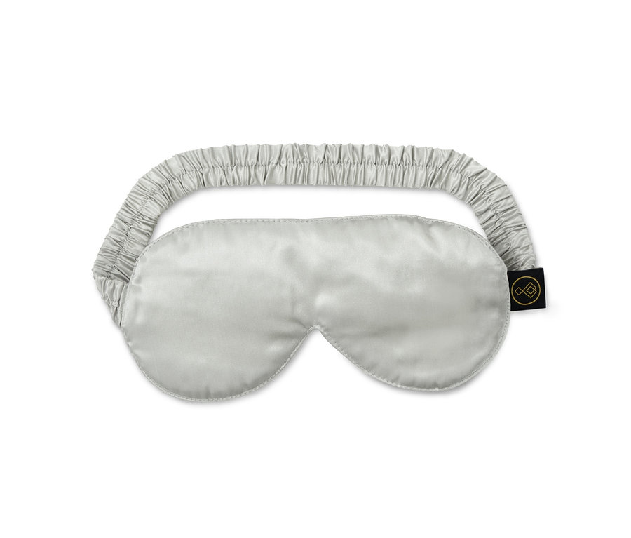 Un masque de nuit en soie argenté avec un cordon de serrage élastique.