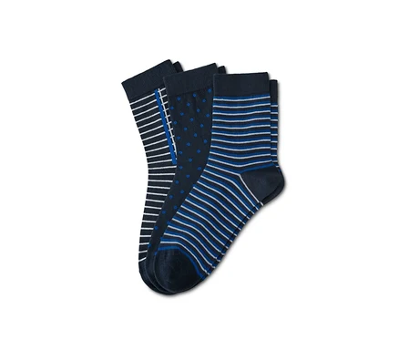 Trois paires de chaussettes avec différents motifs. Une paire avec des rayures, une paire avec des pois et une paire avec des rayures bleues et blanches.