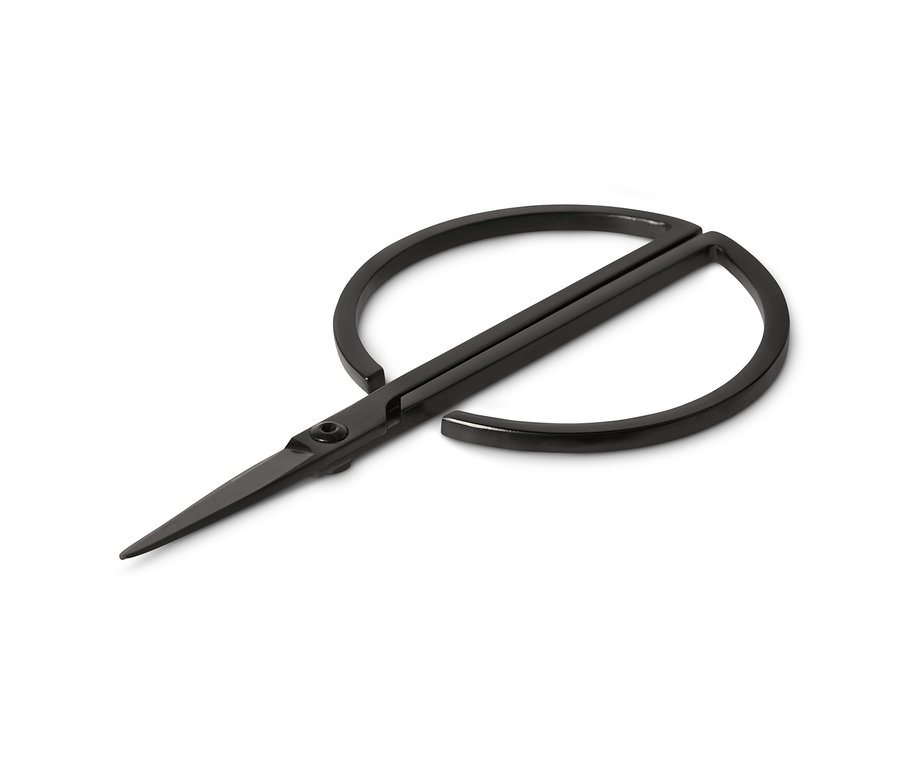 Des ciseaux à herbes noirs sont ouverts sur un fond blanc.