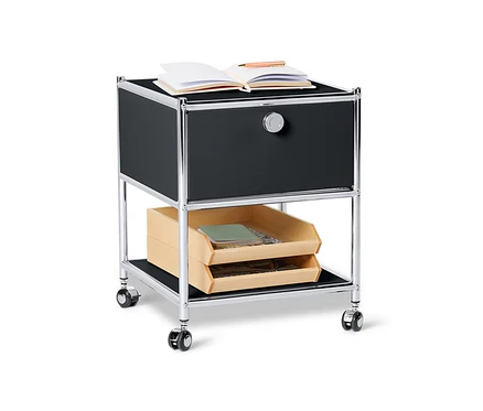 Table d'appoint en métal noire « CN3 » avec tiroir et un livre ouvert sur le dessus.