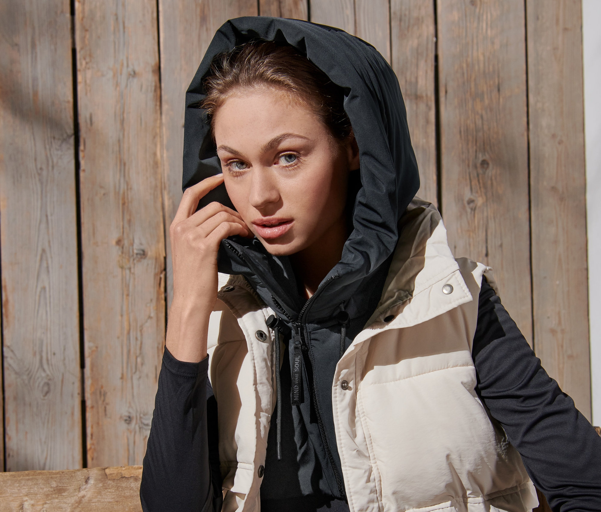 Une femme portant une capuche matelassée avec un col montant et un gilet.