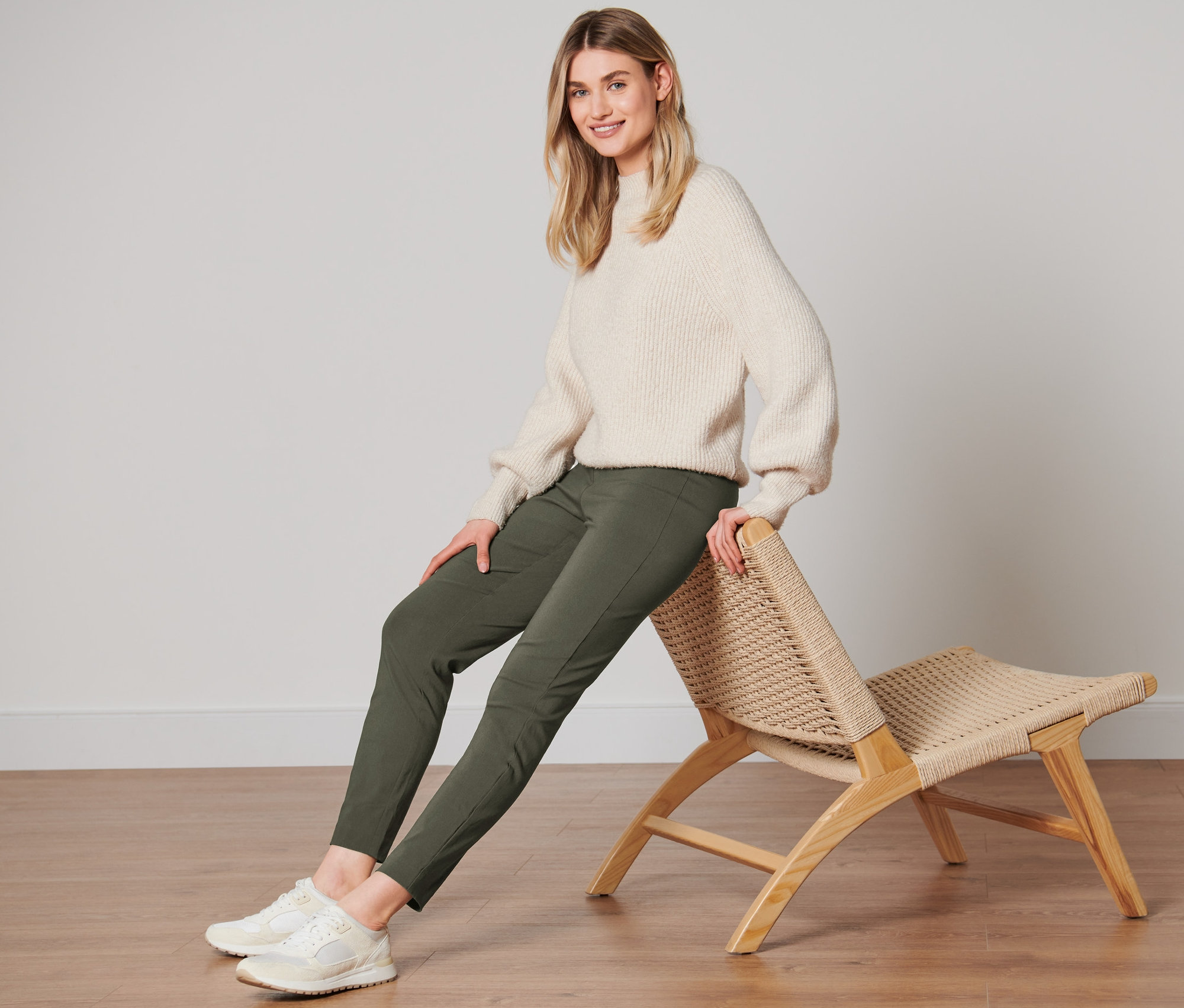 Une femme est assise sur une chaise et porte un pantalon stretch.
