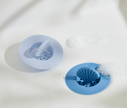 Deux tamis d'évier en silicone dans l'évier. Un bleu clair et un bleu.