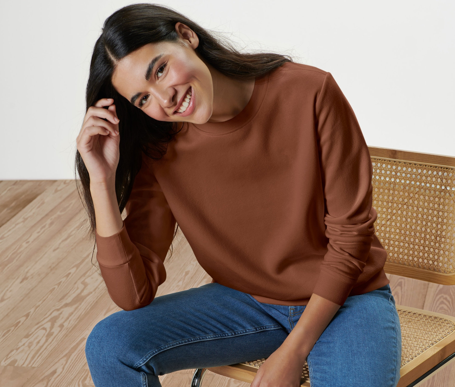 Femme assise sur une chaise portant un sweat-shirt.