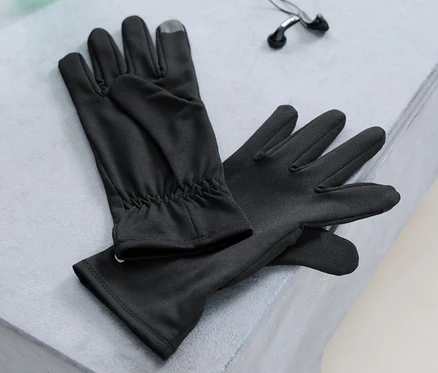 Des gants de course, une bouteille d'eau et des écouteurs sont posés sur un banc.