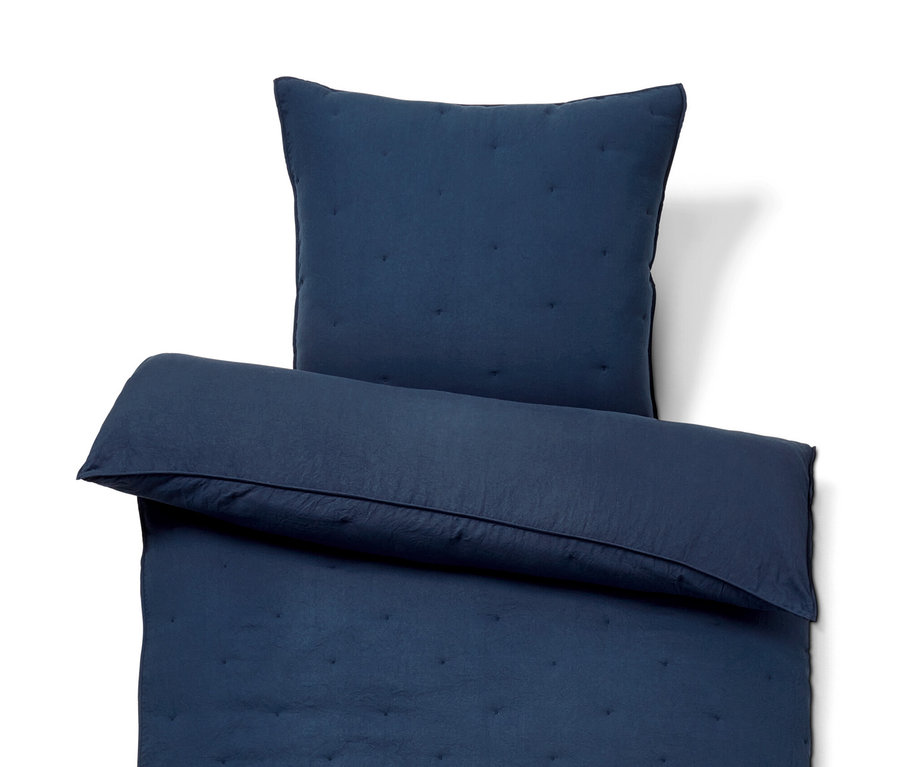 Un ensemble de literie bleu marine avec motif matelassé.