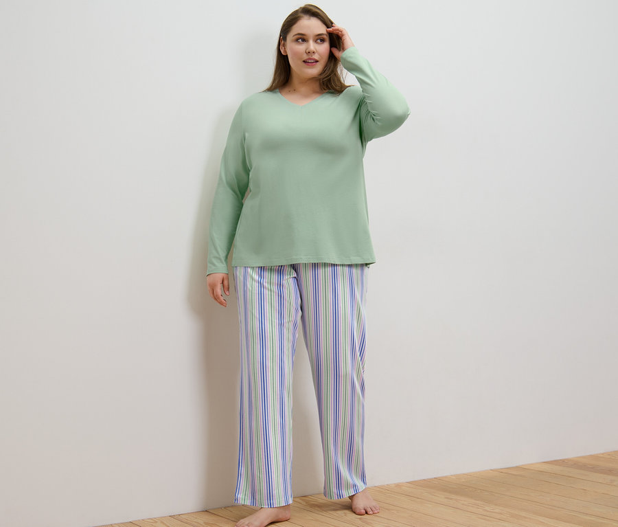 Une femme portant un pyjama se tient dans une pièce.