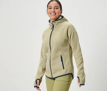 Une femme porte une veste en polaire tricotée jaune.