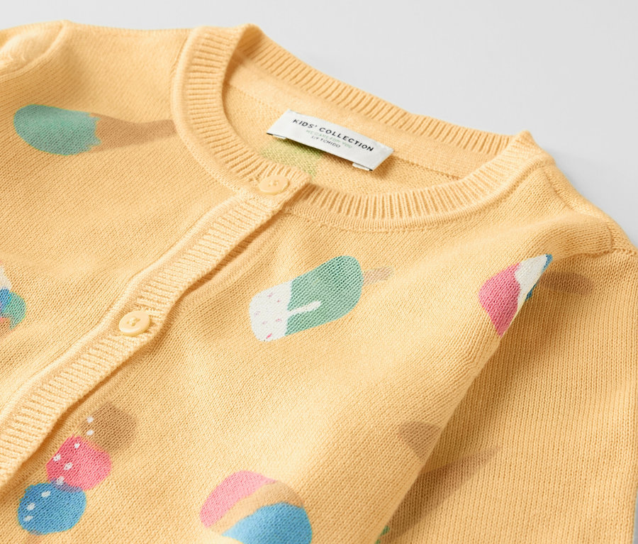Gros plan sur un veste en maille pour enfant avec un motif de crème glacée.