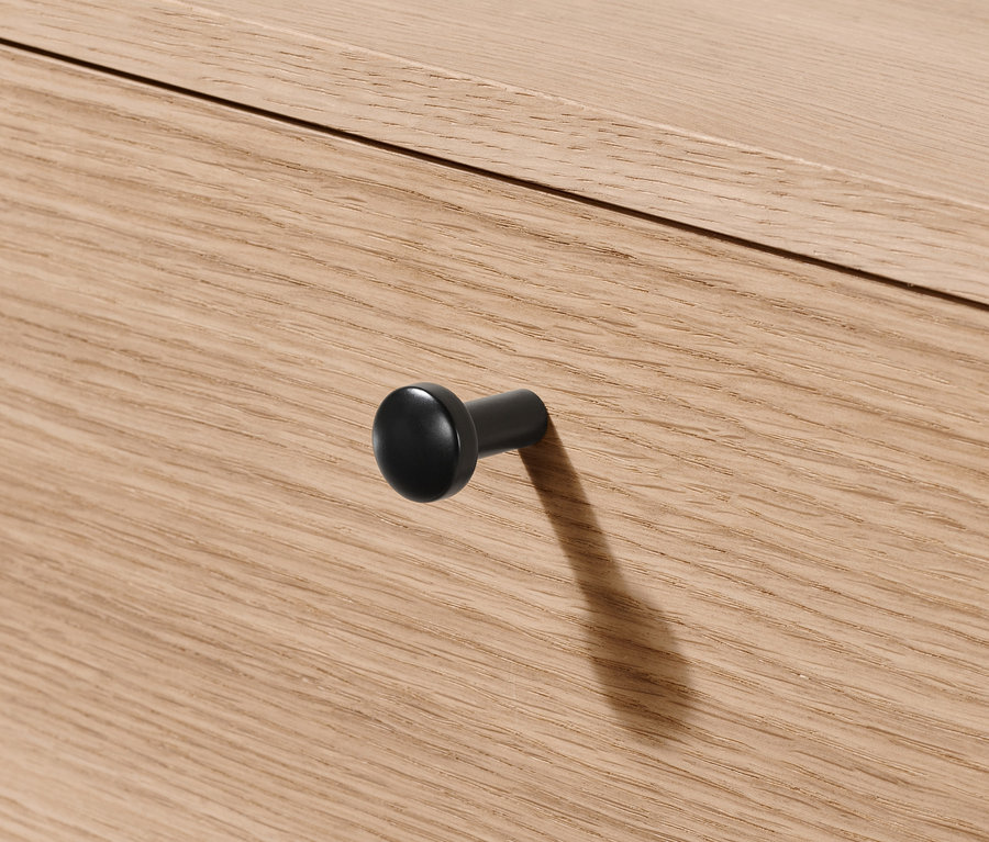 Détail du tiroir de la commode »Finnsbo« avec une poignée ronde noire.