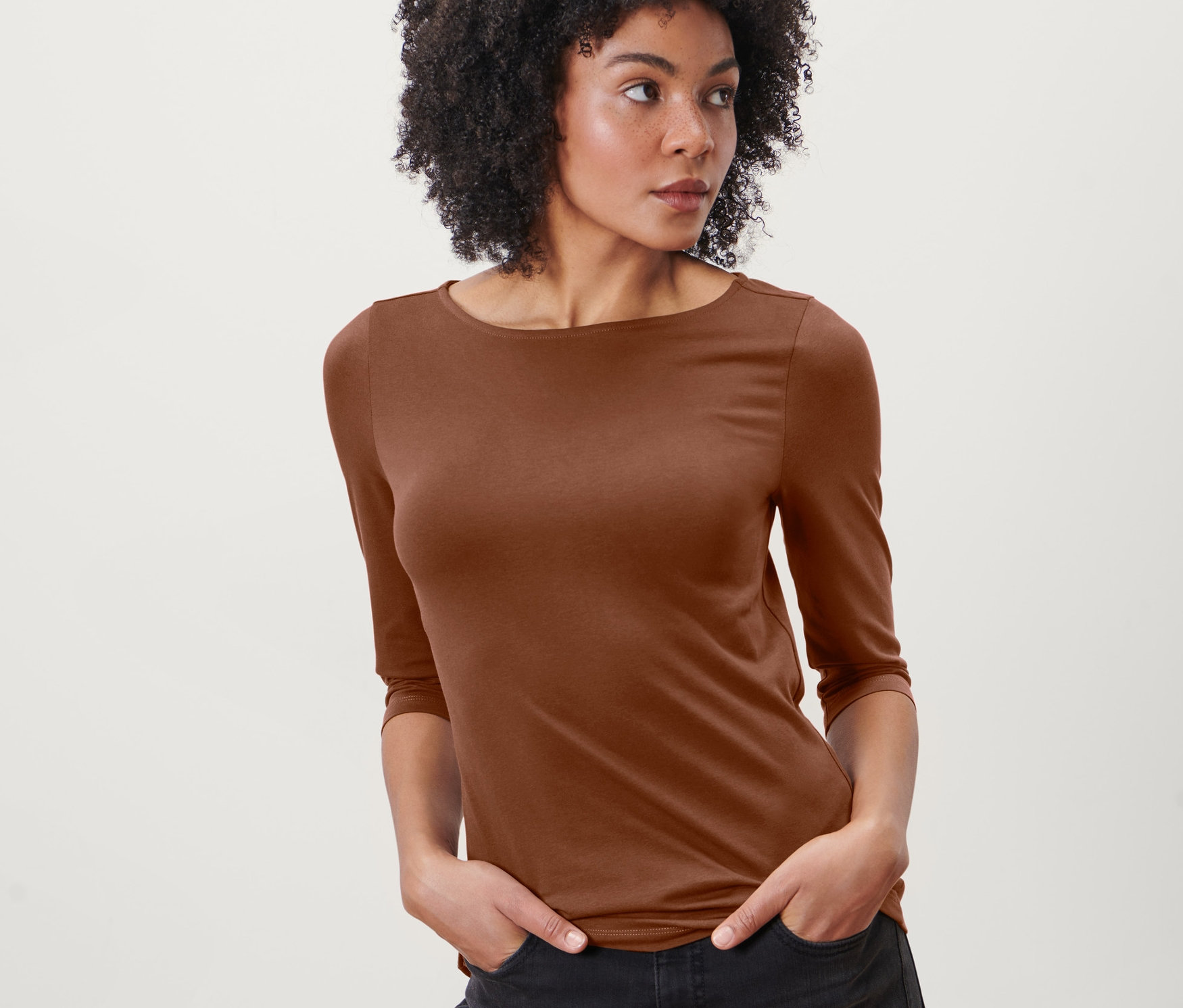Femme afro-américaine posant dans un t-shirt cognac à manches 3/4.