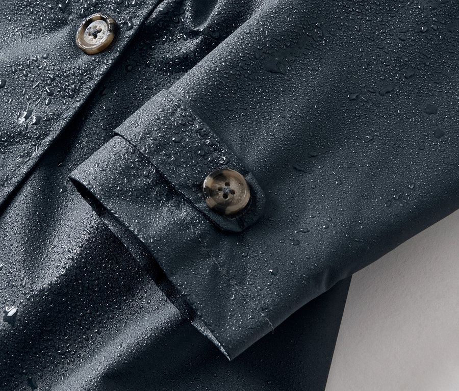 Gros plan sur un trench-coat tout-temps pour enfant avec des gouttes d'eau.