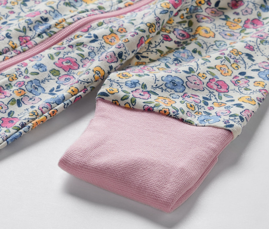 Gros plan sur un pyjama pour bébé à motif floral.