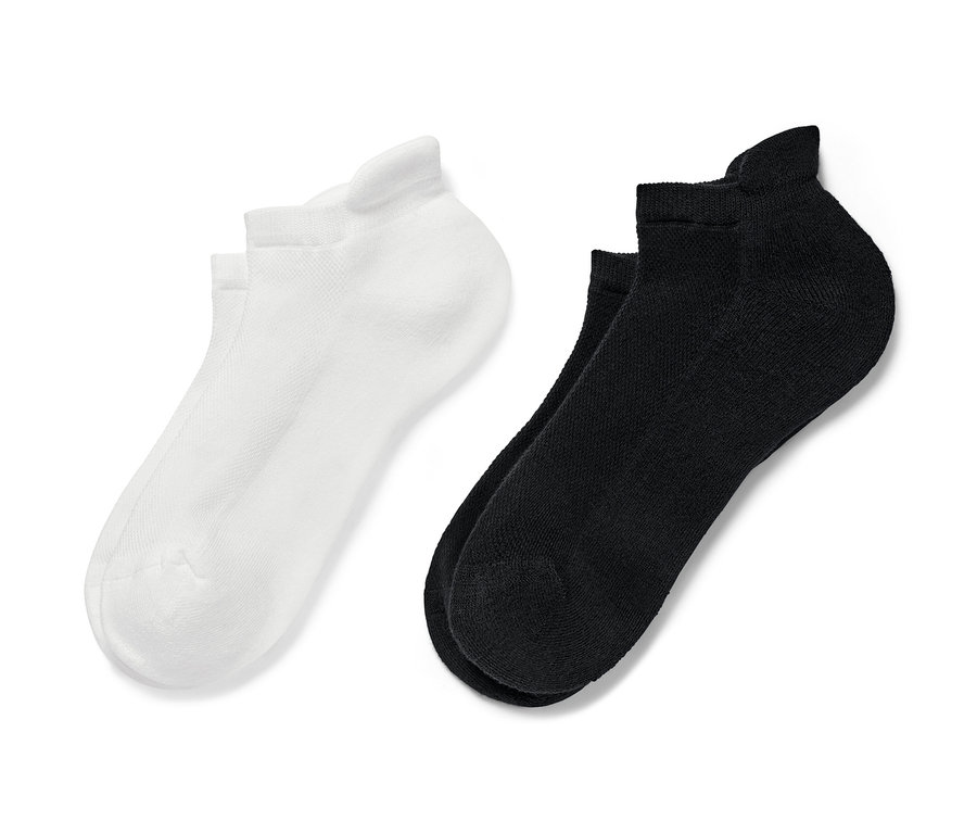 Deux paires de socquettes de sport, une paire noire et une paire blanche.