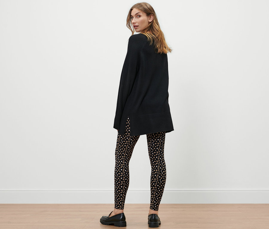 Une femme, vue de dos, porte une robe noire et un legging à motif intégral.