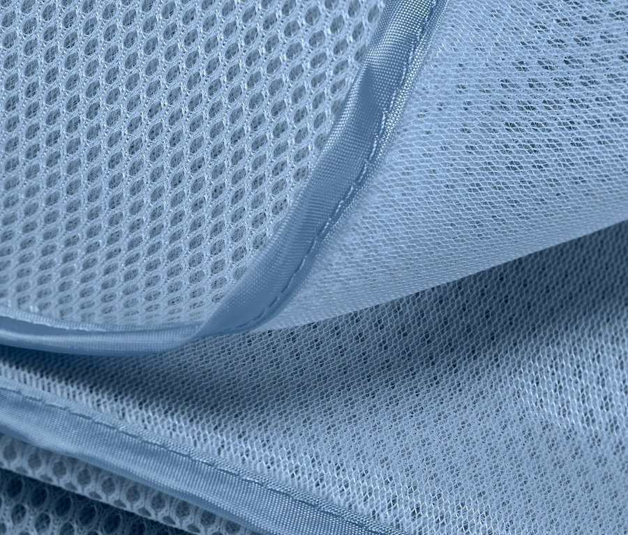 Gros plan d'une couverture de plage anti-sable montrant la texture et la respirabilité du matériau.