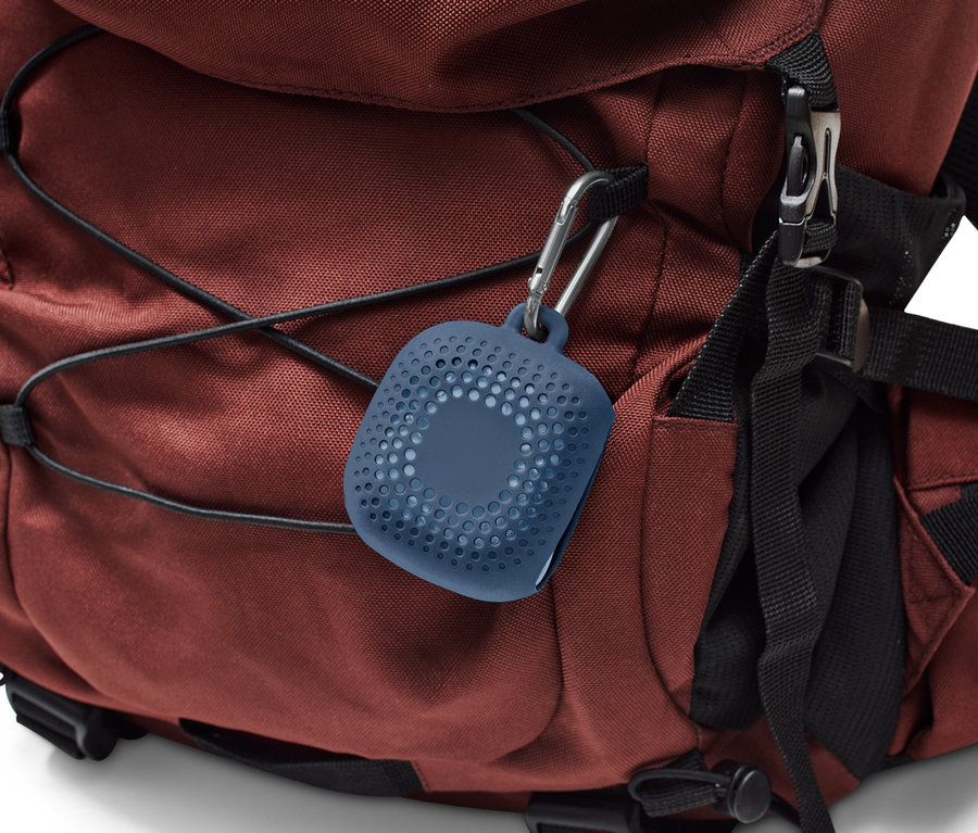 Une serviette de toilette d’extérieur bleue est attachée à un sac à dos marron avec un mousqueton.