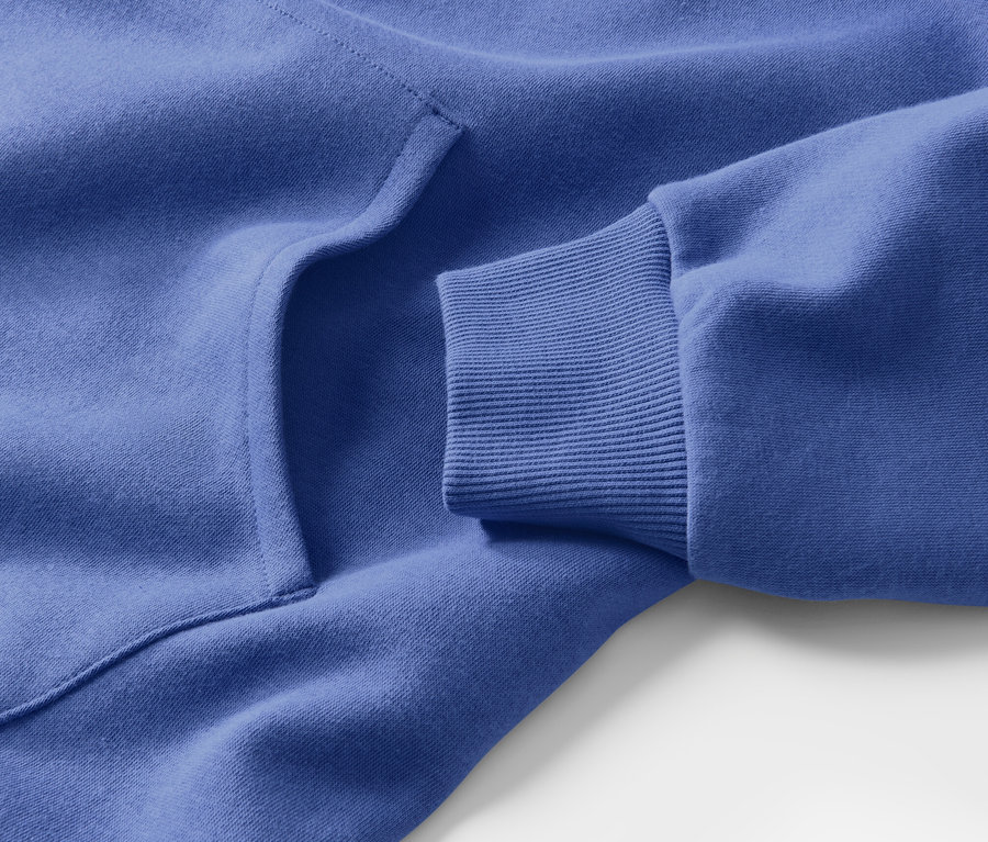Gros plan sur une robe d’intérieur bleue avec une poche et un bord de manche côtelé.