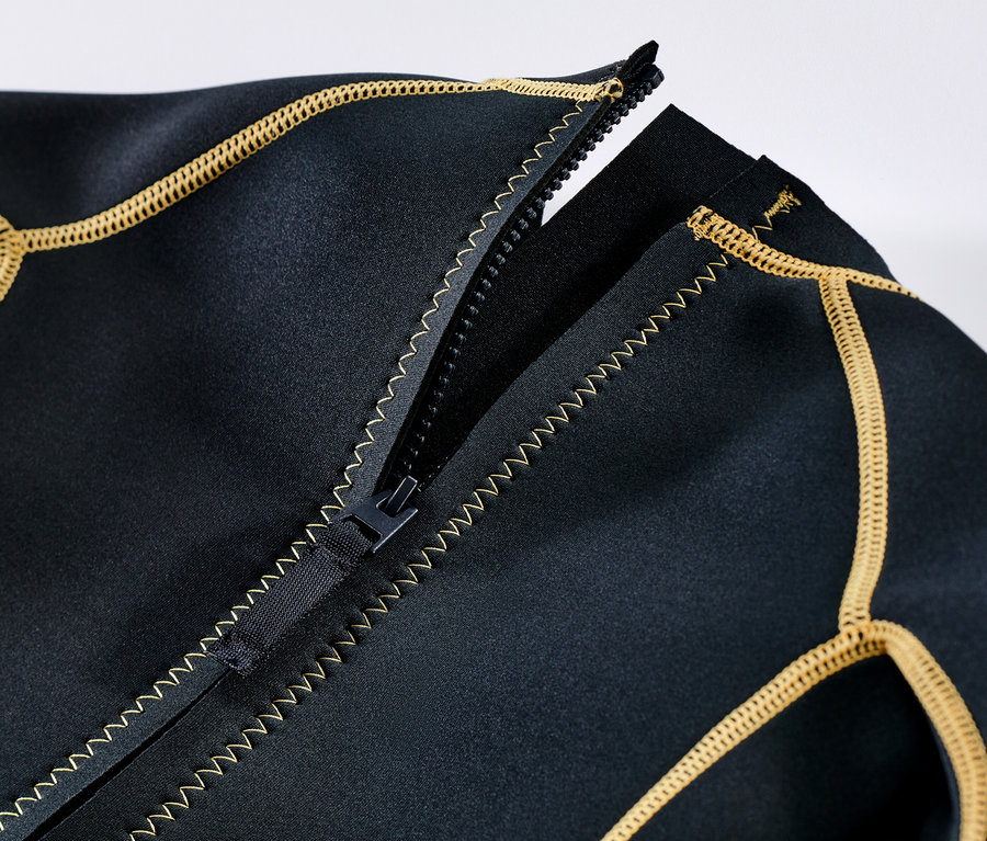 Gros plan sur un costume en néoprène pour enfant avec une fermeture éclair ouverte et une bordure jaune.