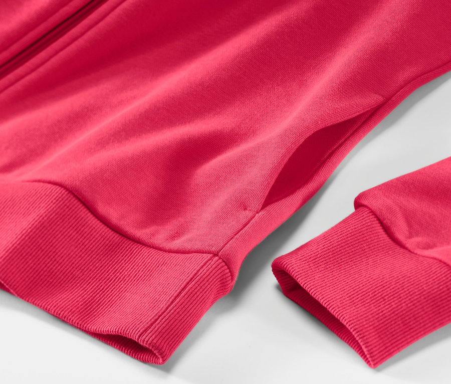 Détail d'une jaquette en sweat rose vif.