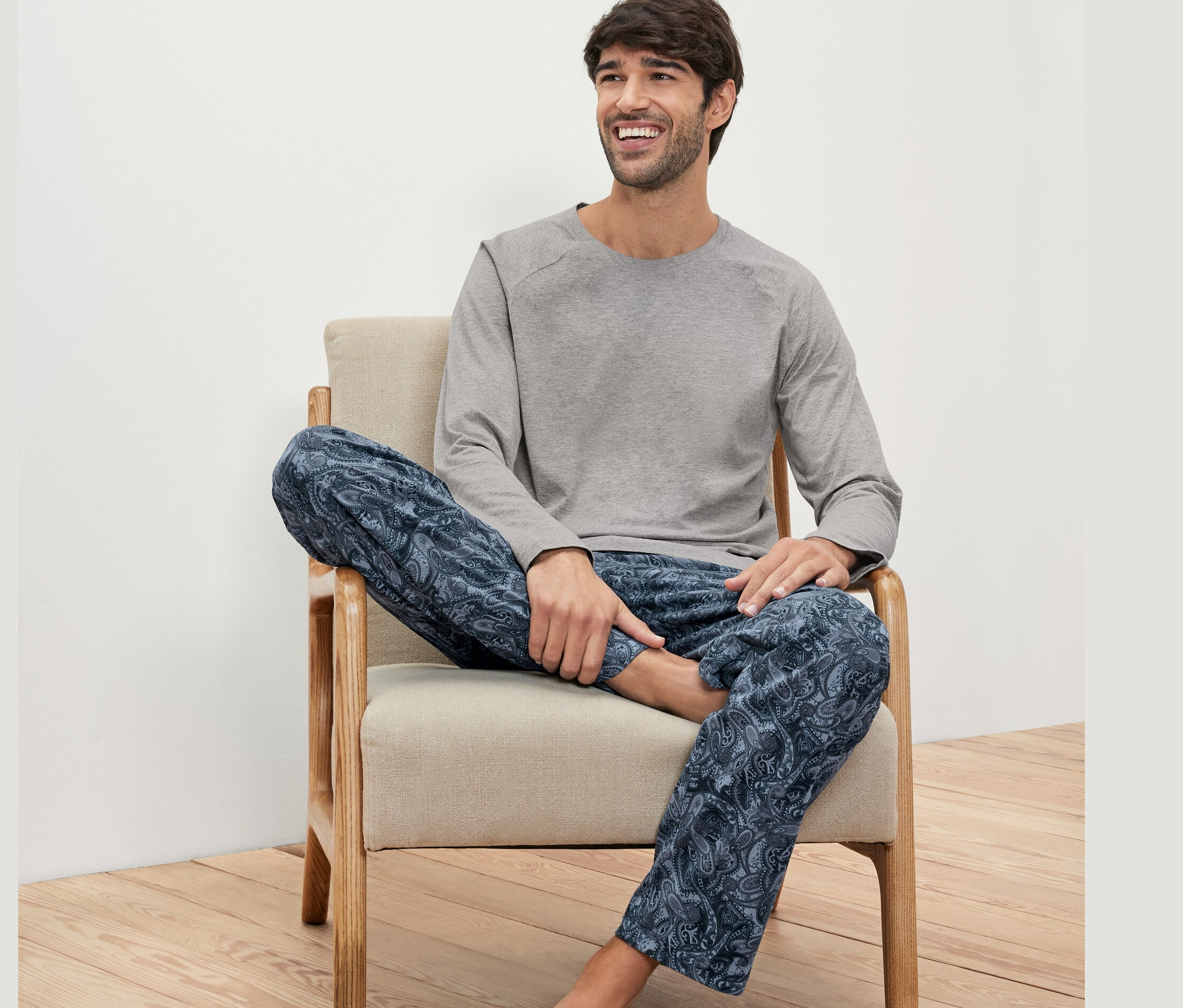 Un homme assis dans un fauteuil et portant un ensemble pyjama.