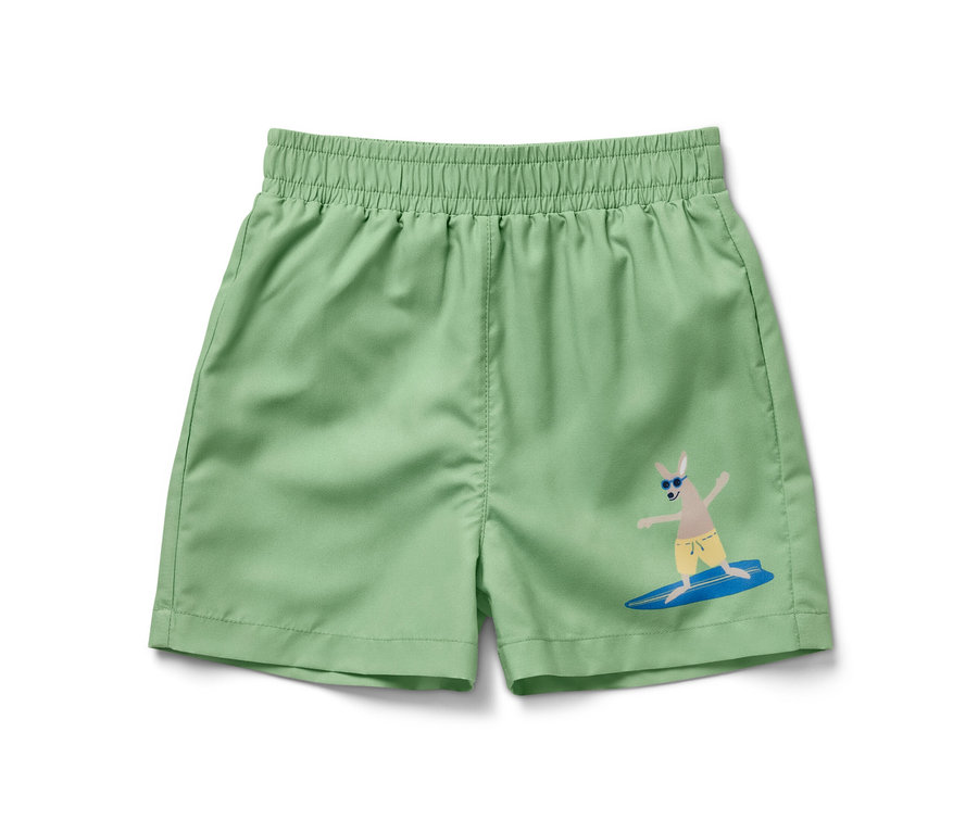 Boardshort pour enfant vert avec un motif de kangourou surfant sur une vague.