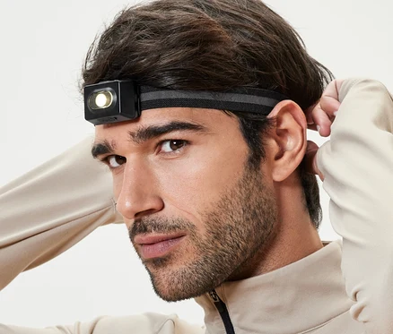 Un homme ajuste sa lampe frontale.