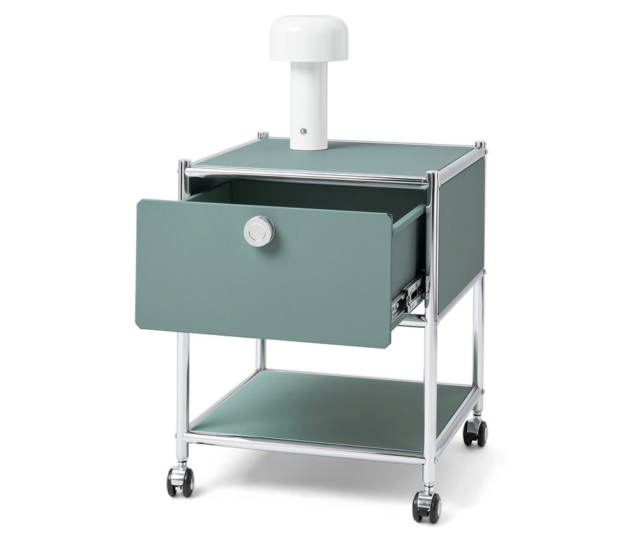 Table de chevet verte avec tiroir ouvert et lampe blanche sur le dessus.